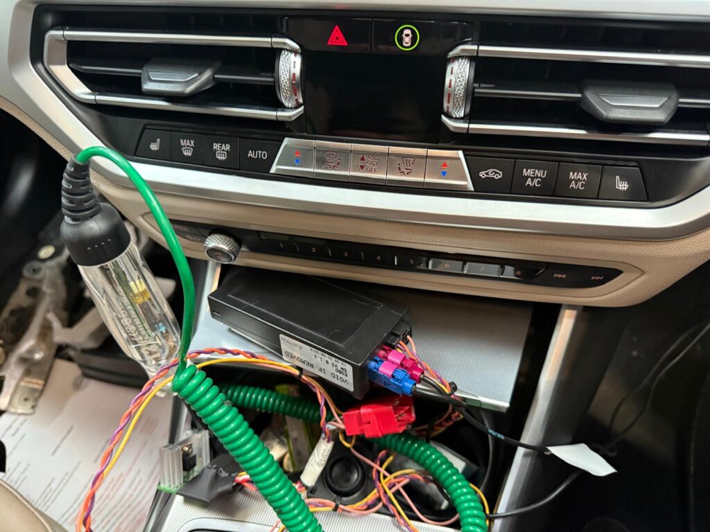 Electrician auto Carfix efectuând o diagnoză electrică avansată la modulul de control al climatizării (HVAC) al unei mașini moderne în service-ul din Londra.